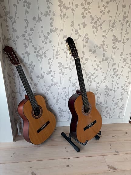 Två klassiska gitarrer med gitarrställ