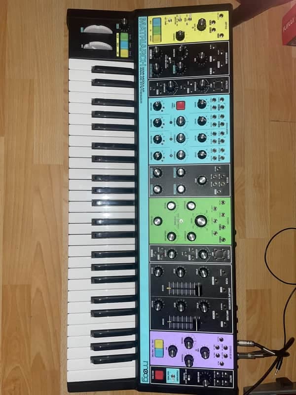 Moog Matriarch 49-Key Semi-Modular Analog Synthesizer (2019–Present) – Black / Multi-Colored Panel, including a travel bag and protective plastic cover.